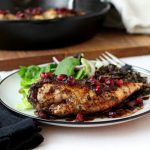 Pomegranate-Cranberry Chicken on a white and black plate with a fork