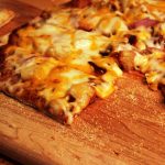 Barbecue pulled pork pizza on a cutting board
