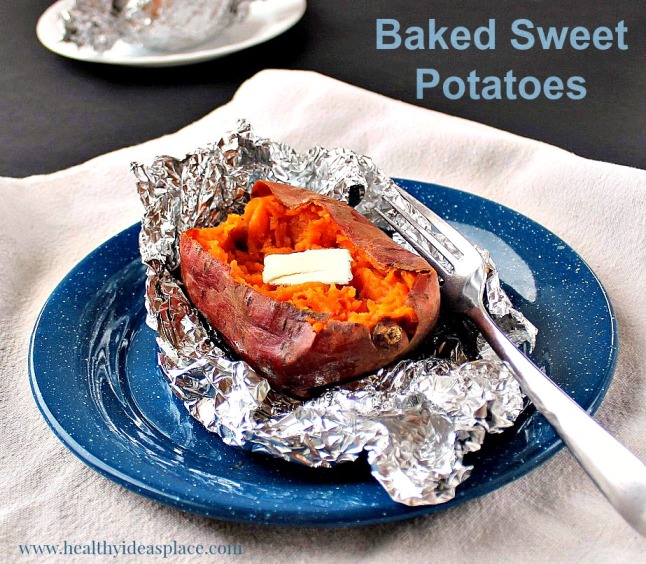 Baked sweet potato with butter on foil and blue plate