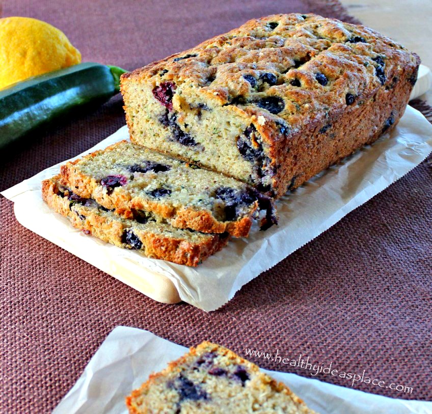 Zucchini Bread with Blueberries and Lemon with a lemon and a zucchini behind