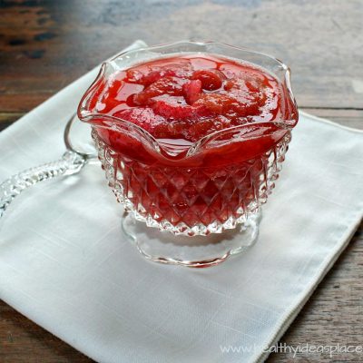 Strawberry Rhubarb Compote in a bowl with a spoon in the background