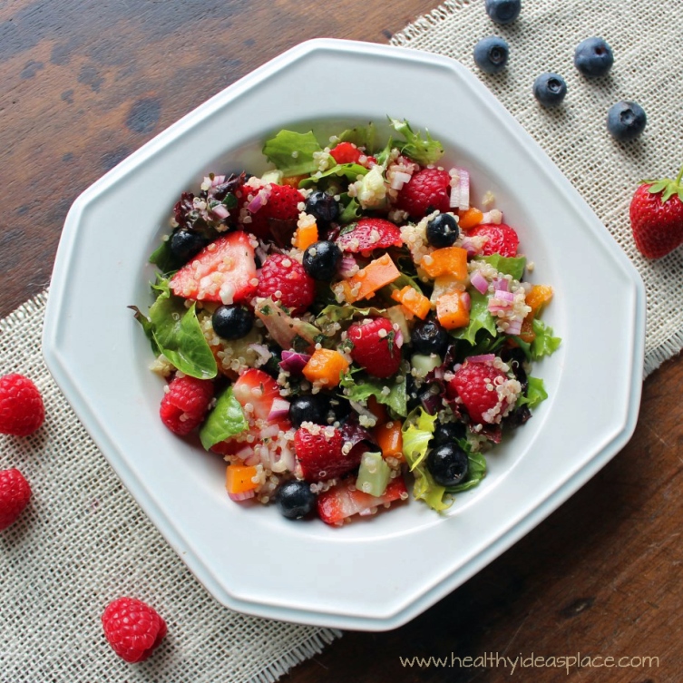 Triple Berry and Quinoa Salad with Mixed Greens places sweet berries and nutty quinoa amidst a backdrop of earthy mixed greens, cucumbers, and peppers, all pulled together with a balsamic vinaigrette for a colorful and scrumptious salad.