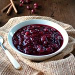 Cranberry Sauce with Red Wine and Ginger in a white bowl sitting on a towel