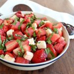 closeup of Strawberry Watermelon Caprese Salad in a blue striped white bowl