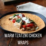 Warm Tzatziki Chicken Wrap unrolled on a black plate