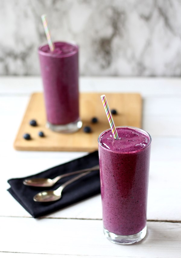 Blueberry banana smoothies in clear glasses with straw