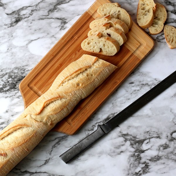 Baguette partially sliced on cutting board