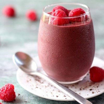 berry smoothie with chocolate on white plate in clear glass