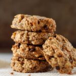 4 Breakfast cookies stacked with 1 leaning against the stack against darker background